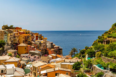 High angle view of townscape by sea against clear sky