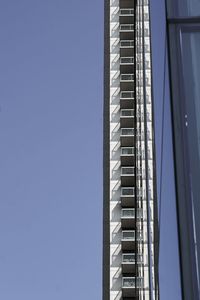 Low angle view of modern building against blue sky