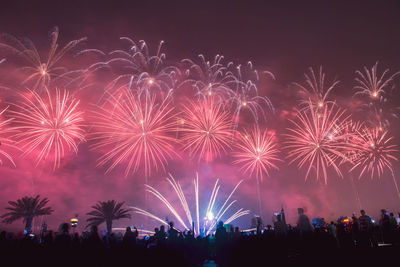 Low angle view of firework display at night