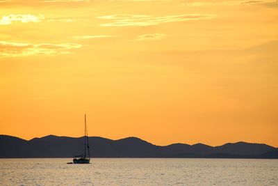 Silhouette sailboat on sea against sky during sunset