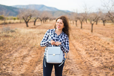 Portrait of smiling young woman on land