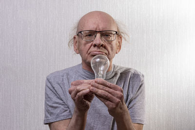 Portrait of man wearing sunglasses against wall