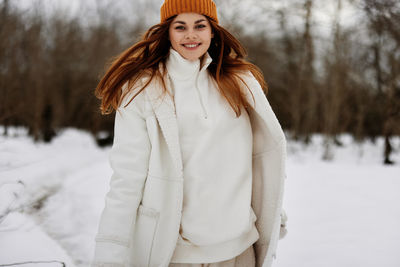 Portrait of young woman standing in snow