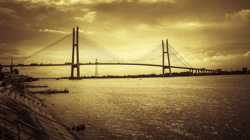 View of suspension bridge against cloudy sky