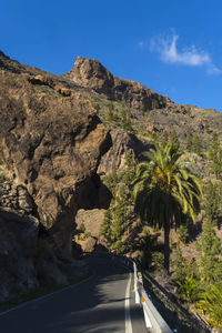 Road amidst rocks and mountains against sky