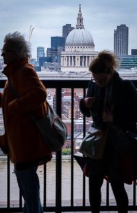 Rear view of man and woman standing in city