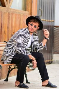 Full length of young man sitting outdoors