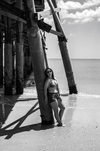 Woman standing against pier at beach