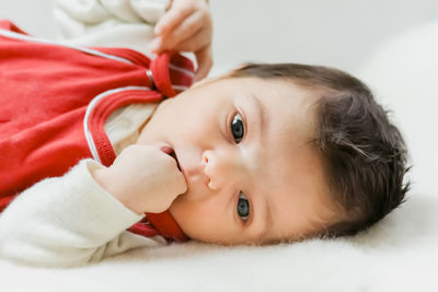 Close-up portrait of cute baby lying on bed