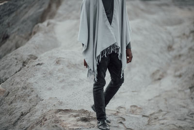 Low section of man standing on beach