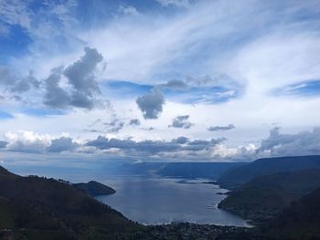 Scenic view of sea and mountains against sky