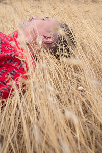 Midsection of woman with hay bales in field
