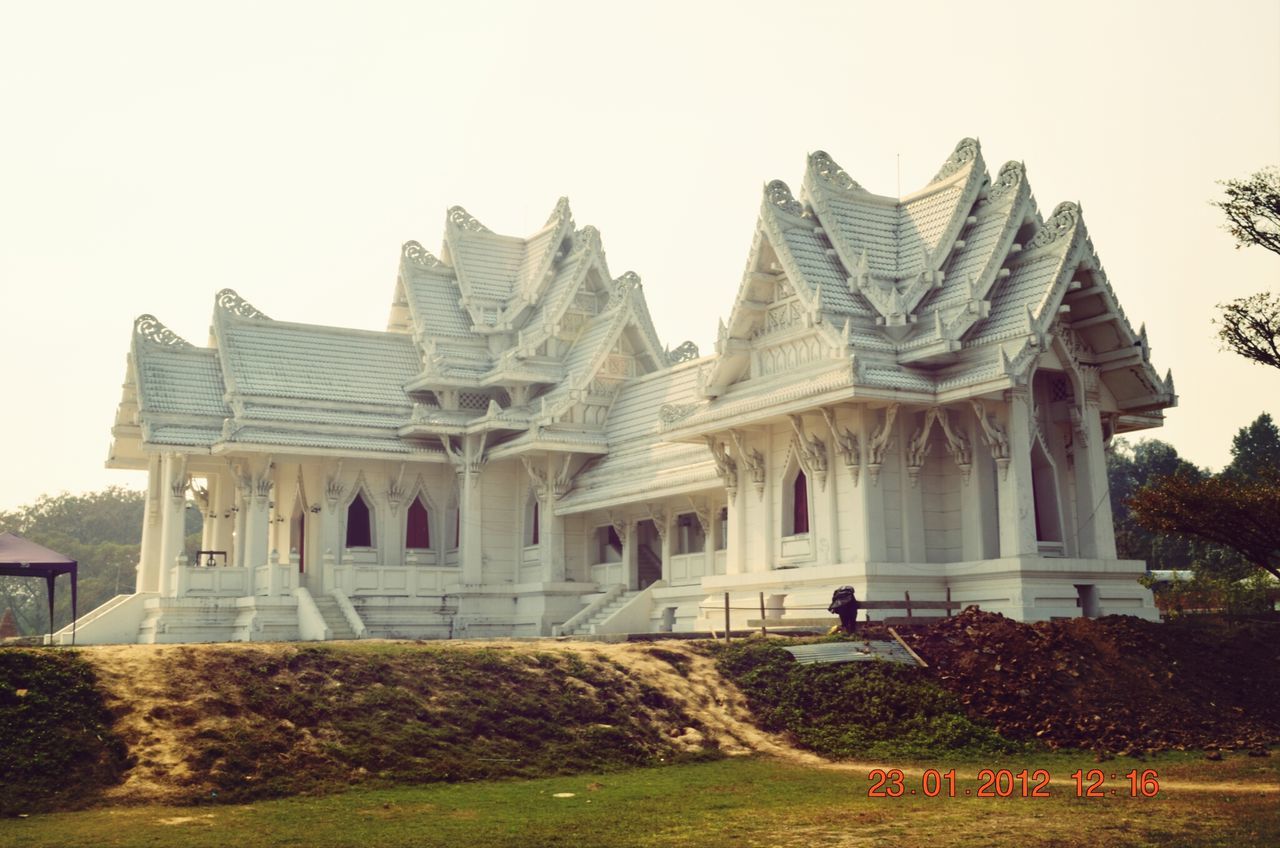 architecture, building exterior, built structure, clear sky, grass, facade, sky, tree, history, lawn, place of worship, exterior, religion, house, day, outdoors, spirituality, copy space, plant, travel destinations