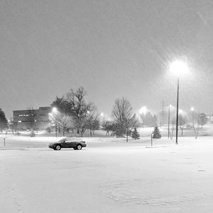 Cars on snow covered road against sky