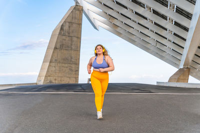 Young woman running on road