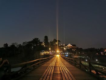 Railroad tracks against sky at night