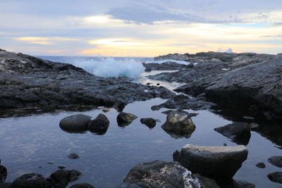 Rocks in sea against sky