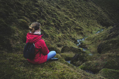 Rear view of woman sitting on land