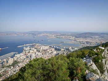 High angle view of townscape by sea against clear sky