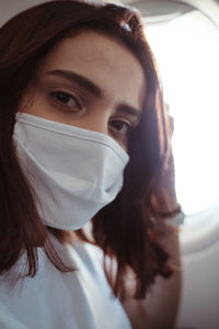 Close-up portrait of woman covering face with a mask. 