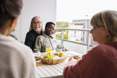 Family sitting at table on balcony