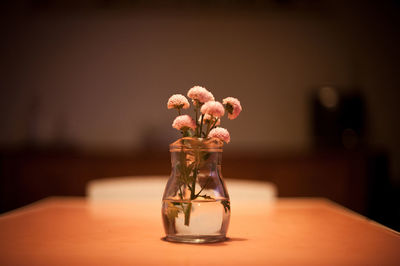 Small pink flowers in jar on table