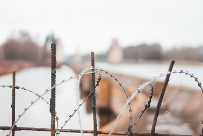 Close up of barbed wire against water canal