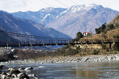 Bridge over river against mountains