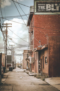 Street amidst houses against buildings in city