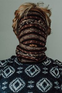 Portrait of person wearing hat against gray background