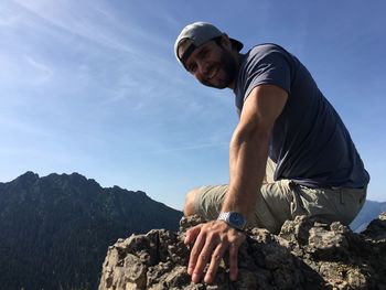 Rear view of man on rock against sky