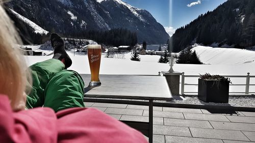 Rear view of people sitting on snow covered mountain