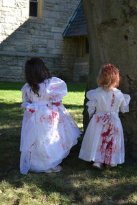 Rear view of girls wearing halloween costume standing on field