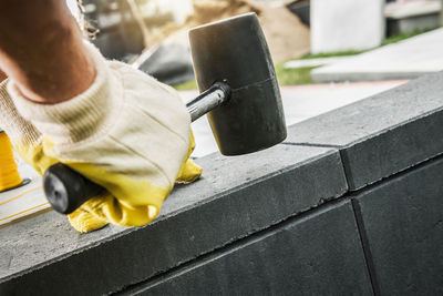 Cropped hand of man cutting metal