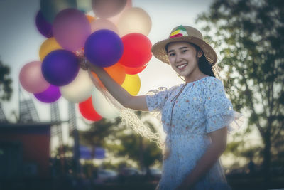 Portrait of smiling boy holding balloons