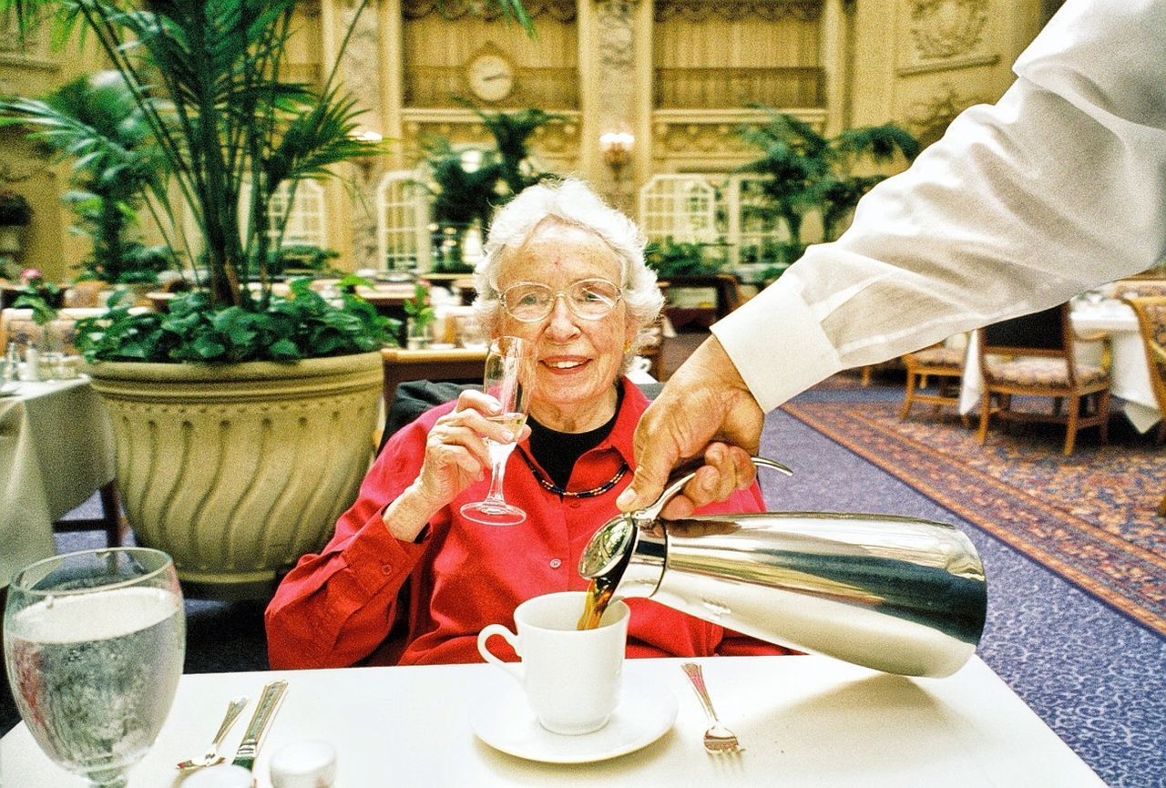 indoors, person, looking at camera, table, portrait, sitting, casual clothing, lifestyles, leisure activity, smiling, front view, food and drink, chair, drink, holding, restaurant, childhood, incidental people