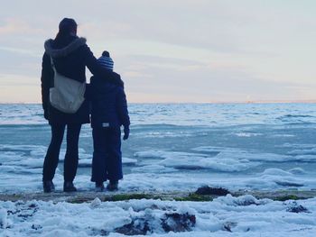 Rear view of couple standing on beach