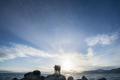 Group of friends silhouetted on a rock at sunset in lake tahoe, ca