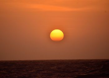 Scenic view of sea against orange sky