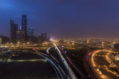 Aerial view of illuminated city street and buildings at night