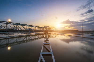 Bridge over river against sky during sunset