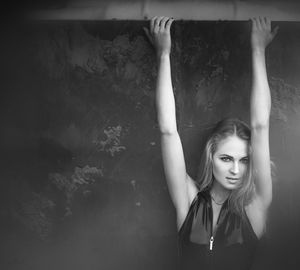 Portrait of young woman with arms raised