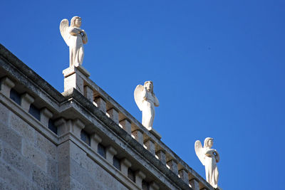 Low angle view of statue against clear blue sky