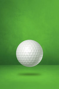 Close-up of ball on table against green background