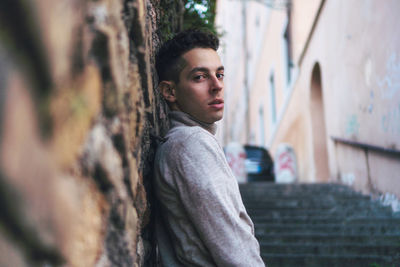 Portrait of young man against tree trunk