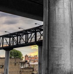 Bridge over river against cloudy sky