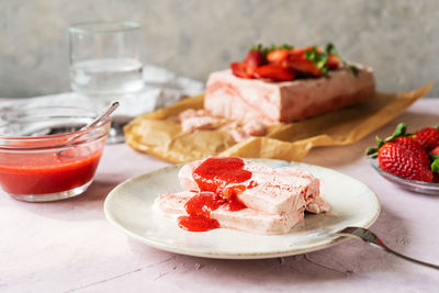 Italian strawberry dessert semifreddo with sauce - cold dessert like an ice-cream sliced on plate