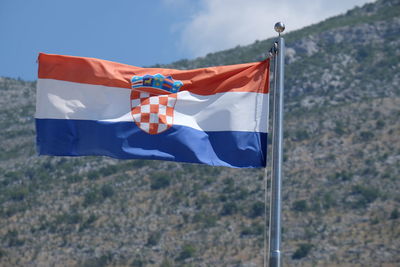 Red umbrella flag on pole against blue sky