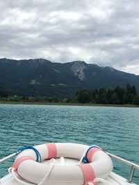 Boat floating on lake against sky