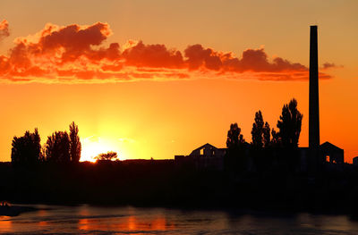 Silhouette built structures against sky during sunset